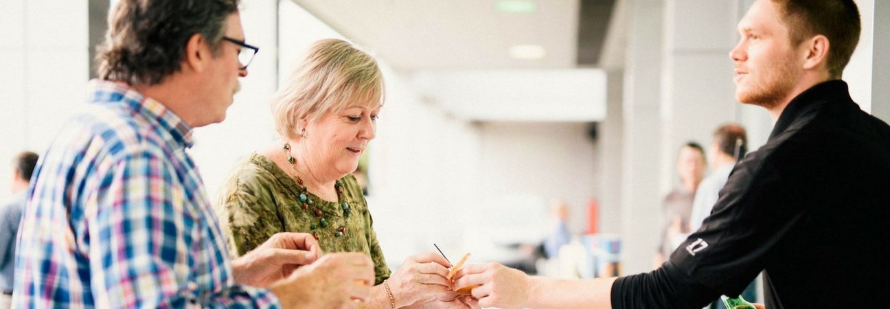 A man handing a couple a food sample at the 2017 Taste of Ardmore