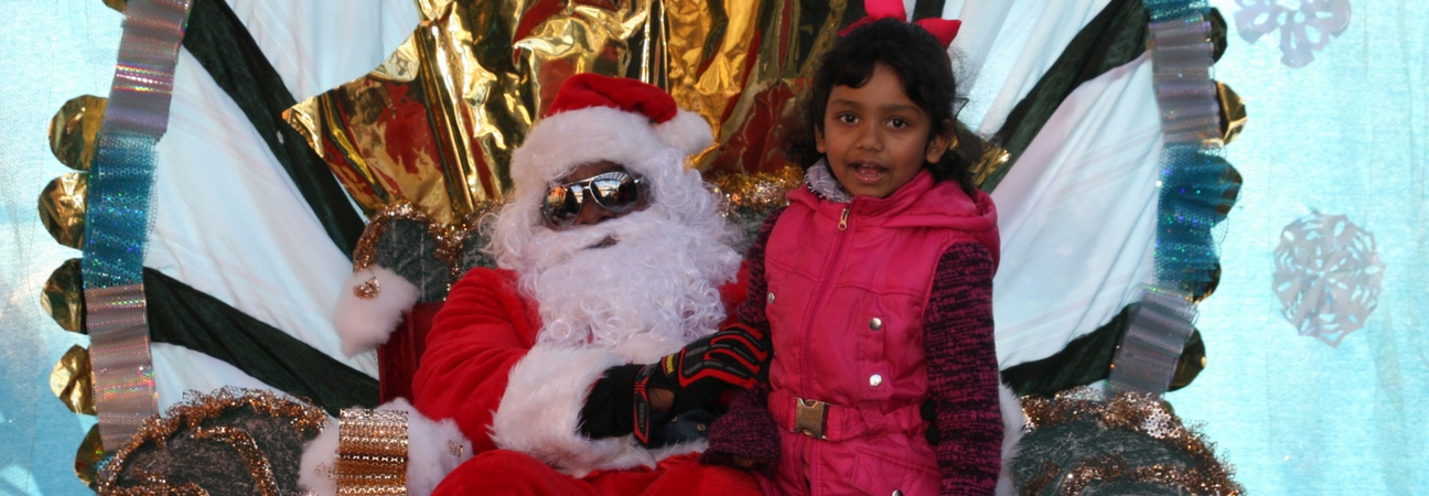 A photo of Santa Clause and a little girl from the Annual Christmas Celebration