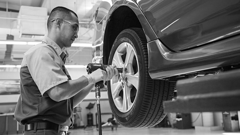 Technician tightening wheel lug nuts