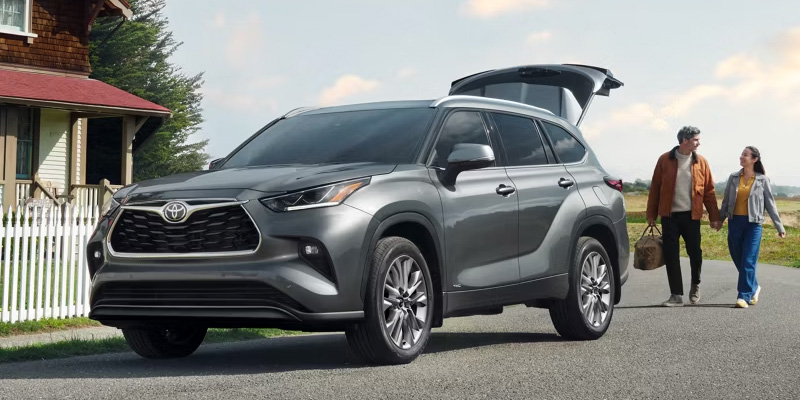 2026 Toyota Highlander three-row SUV with family loading cargo through the open liftgate