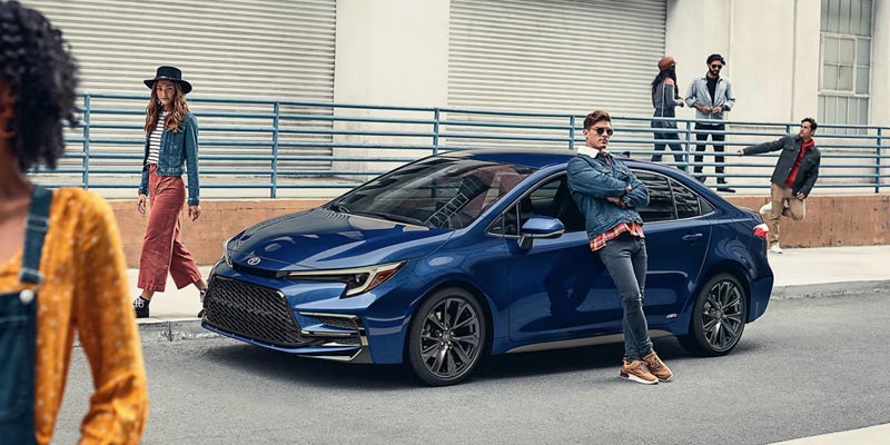 A driver leaning against a trim level option of the 2026 Toyota Corolla in Ardmore, PA